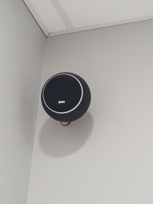une enceinte noire fixée au mur d'une pièce