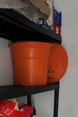 two orange pots on a black shelf in a room