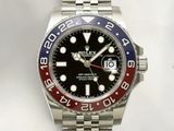 a close up of a wrist watch with a red and blue bezel