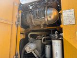 a yellow truck with a large engine in the back of it