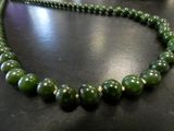necklace made of green jade beads on a black surface