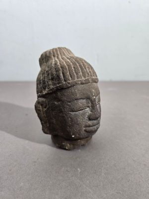 statue représentant la tête d'une personne portant un chapeau sur la tête