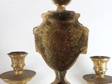 a gold candle holder with three candles on it