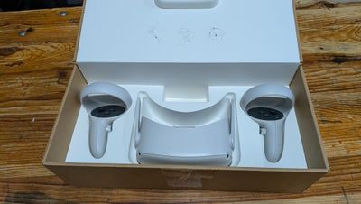 a white box with two remotes in it on a wooden table