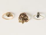 trois anneaux en or et une rose sur fond blanc