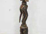 an image of a wooden statue of a woman with a hat on her head