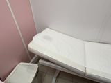 des toilettes roses et un lit blanc dans une petite chambre