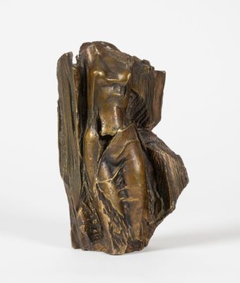 une statue en bronze d'une femme assise sur un rocher