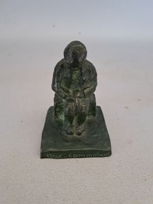 figurine en bronze représentant un homme assis sur un rocher