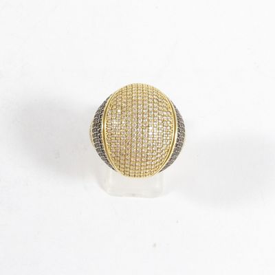 gros plan d'une bague en or et en argent sur une surface blanche