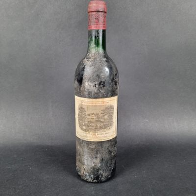 an old bottle of wine sitting on top of a table