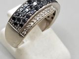 a close up of a ring with black and white diamonds