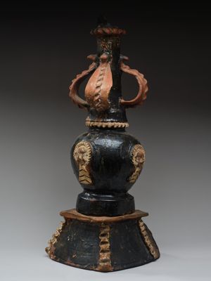 un vase noir orné d'un motif doré sur le dessus