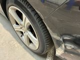 a close up of a car ' s tire on the side of the road