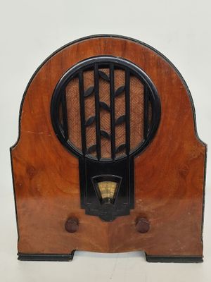 une vieille radio avec un boîtier en bois posée sur une table