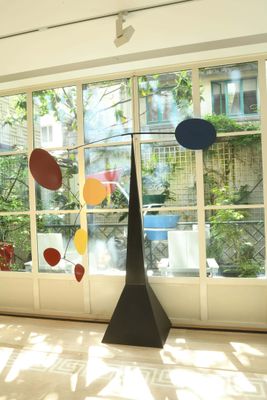 une sculpture au milieu d'une pièce dotée de grandes fenêtres