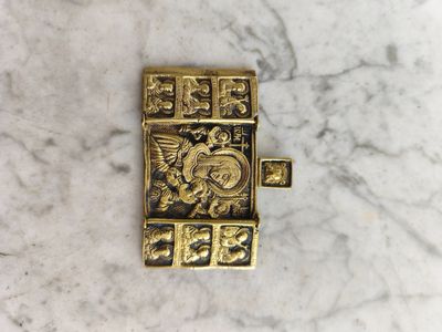 un gros plan d'un objet en métal plaqué or posé sur une surface en marbre