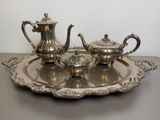 a silver tea set on a silver tray on a table