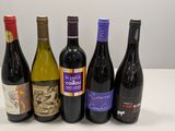 six bottles of wine are lined up on a table