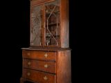 an antique wooden cabinet with glass doors and drawers