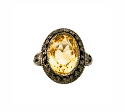 Gros plan sur une bague contenant une pierre jaune