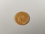 gros plan d'une pièce d'or sur une surface blanche