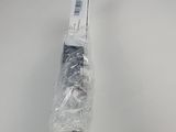 a close up of a black and white umbrella wrapped in plastic on a table
