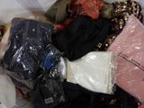 a pile of clothes in a plastic bag on a bed