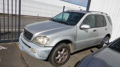 un SUV argenté garé sur un parking à côté d'autres voitures