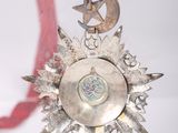 a silver medal hanging from a red ribbon on a table