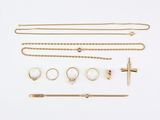 an assortment of gold jewellery including a cross, bracelets, and rings