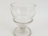 a clear glass cup sitting on top of a glass plate