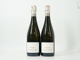 deux bouteilles de vin posées l'une à côté de l'autre sur une surface blanche