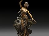 a bronze statue of a woman holding a bird on a pedestal