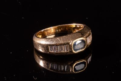 gros plan d'une bague en or sur une surface noire