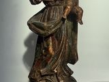 statue en bronze représentant une femme tenant un enfant dans ses bras, posée sur un socle