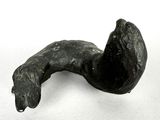 une sculpture noire représentant un chien sur une surface blanche