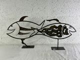 une sculpture métallique représentant un poisson, posée sur un socle
