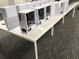 many computers sitting on a table in a room