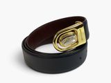 Gros plan sur une ceinture noire avec une boucle dorée