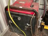 un chat noir assis à côté d'une machine
