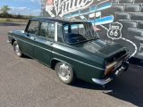 a green station wagon parked in front of a building
