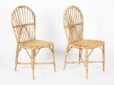 pair of bamboo chairs with wicker backrests against a white background