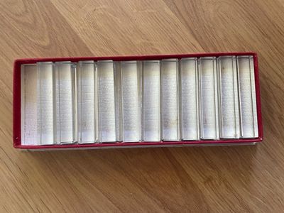 a red box filled with books sitting on top of a wooden floor