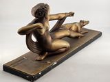 bronze sculpture of a woman and a cat on a wooden base