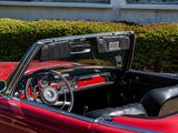 a red and black convertible car parked in front of a building