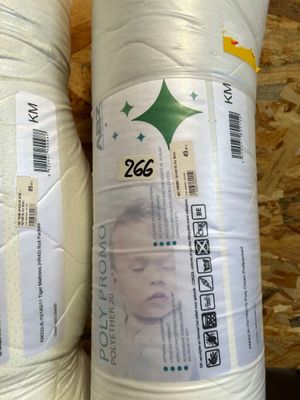 deux pelotes de fil blanc posées sur un parquet