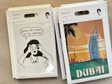 an image of a pair of luggage tags with a picture of a woman and a burj