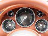 a close up of a steering wheel with gauges and a clock
