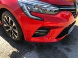 the front end of a red car parked on the side of the road